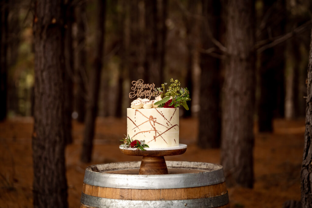 Small wedding cake on a barrel among forest trees