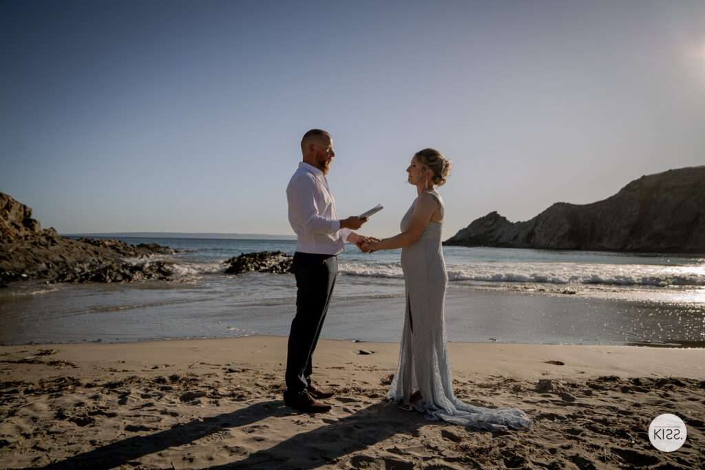 A couple holding hands on the sand at Blowhole Beach