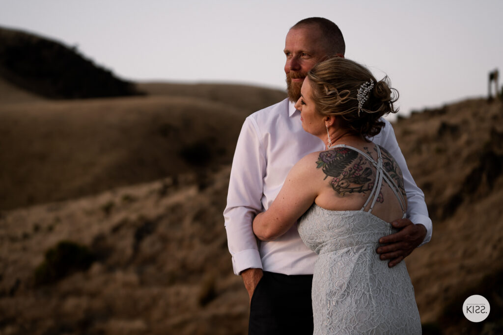 A couple embracing on a coastal hillside