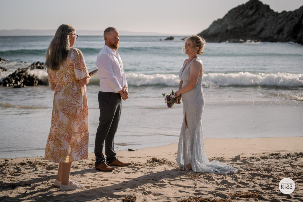 A couple and celebrant at a small beach wedding