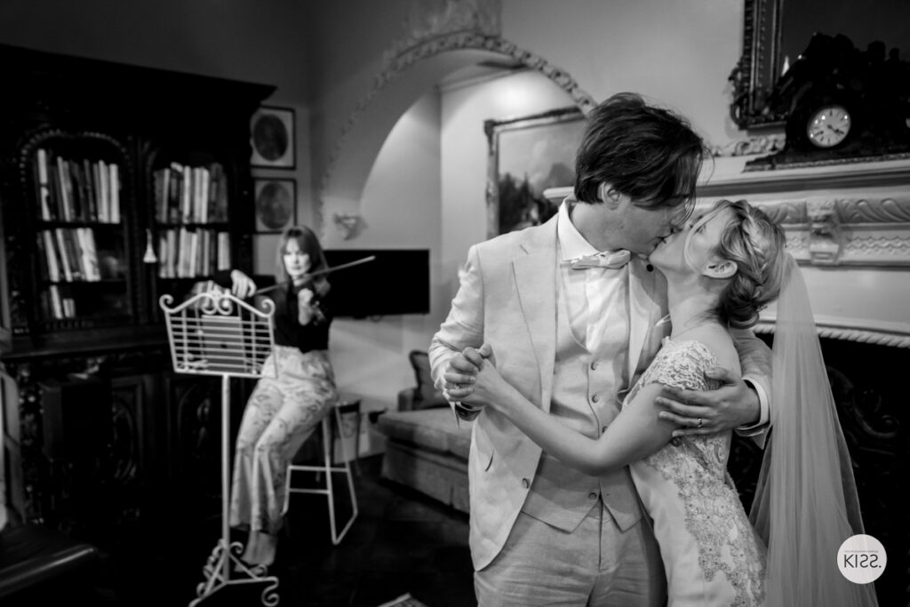 A wedding couple embracing indoors in black and white