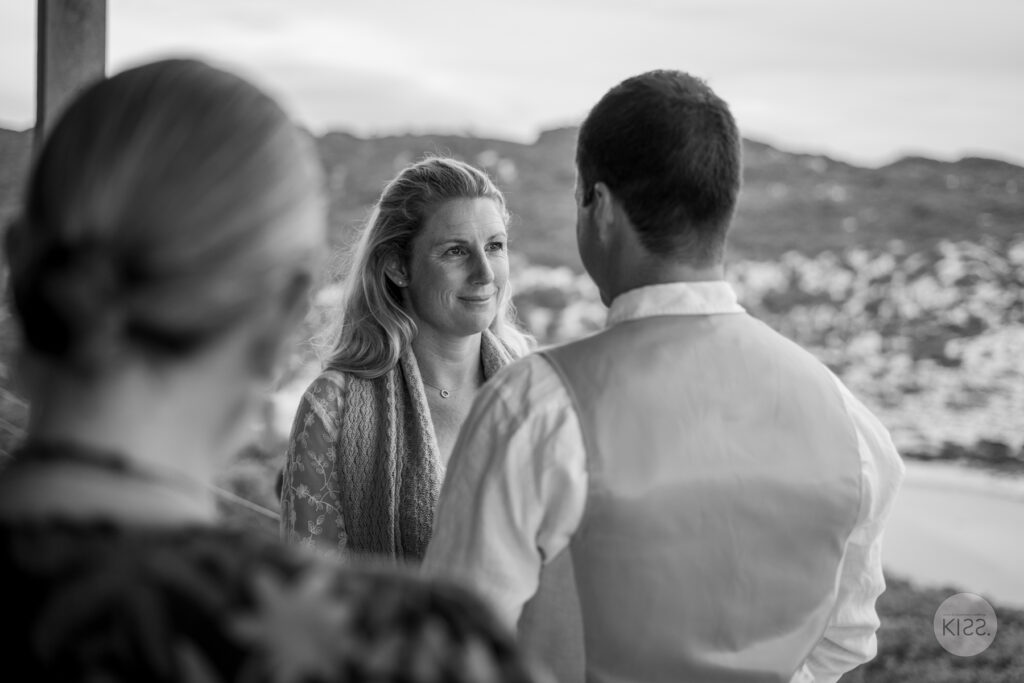 A bride smiling during her vows in black and white