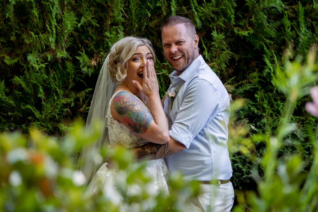 A wedding couple smiling together among flowers