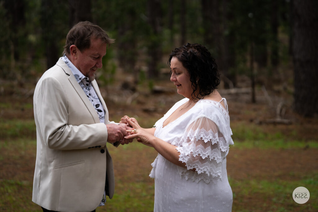 A couple exchanging rings in a forest clearing