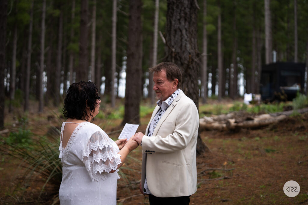 A bride reading her vows to her groom in the forest