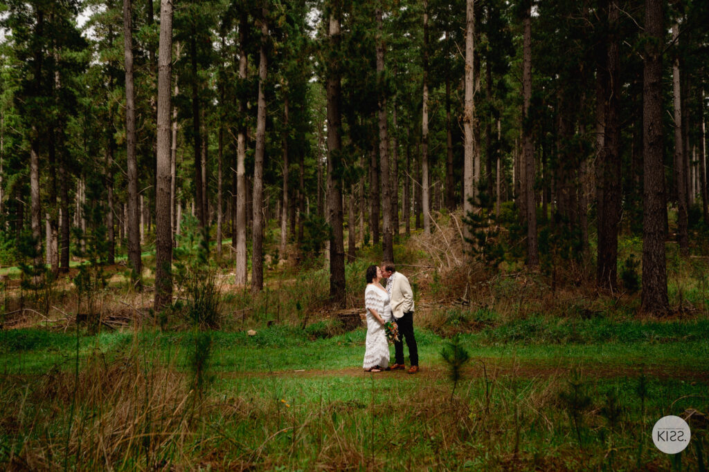 A couple embracing in a green forest clearing