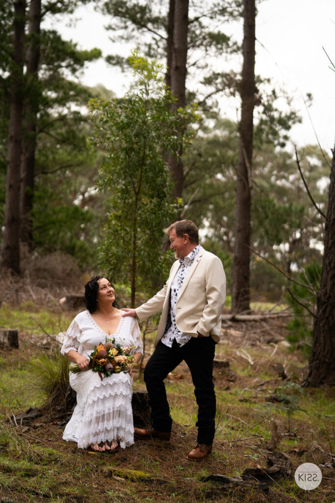 A wedding couple walking hand in hand through the forest