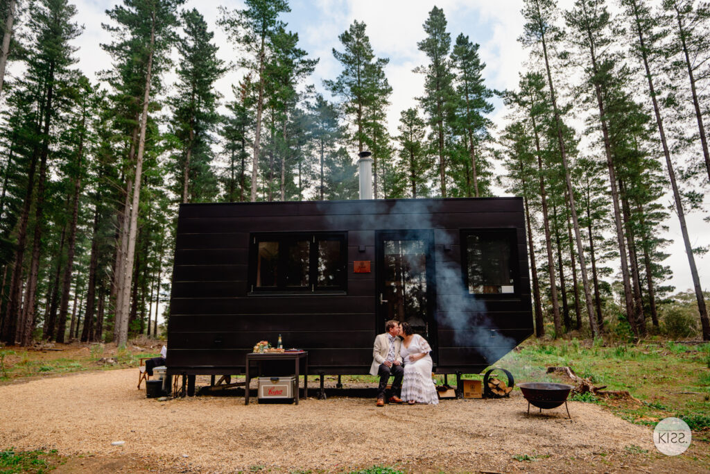 A couple sitting outside CABN Nala among pine trees