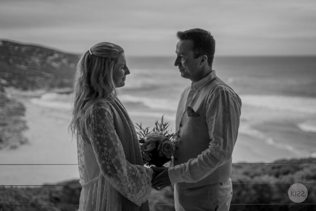 A couple holding hands during their ceremony in black and white