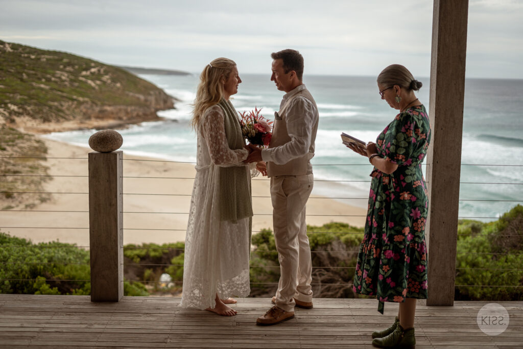 A wedding couple and celebrant overlooking the coast