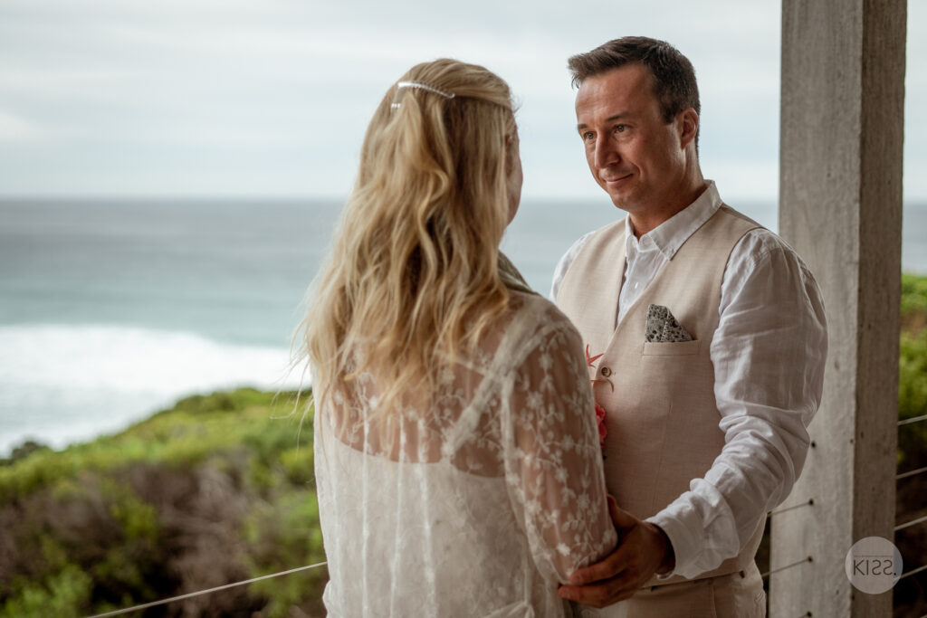 A groom smiling at his bride during their vows