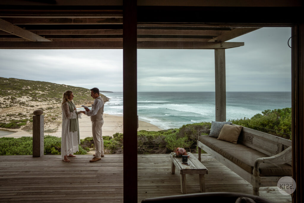 A wedding couple exchanging vows on an ocean-view deck