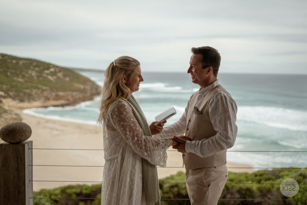 A couple holding hands during an ocean-view wedding ceremony