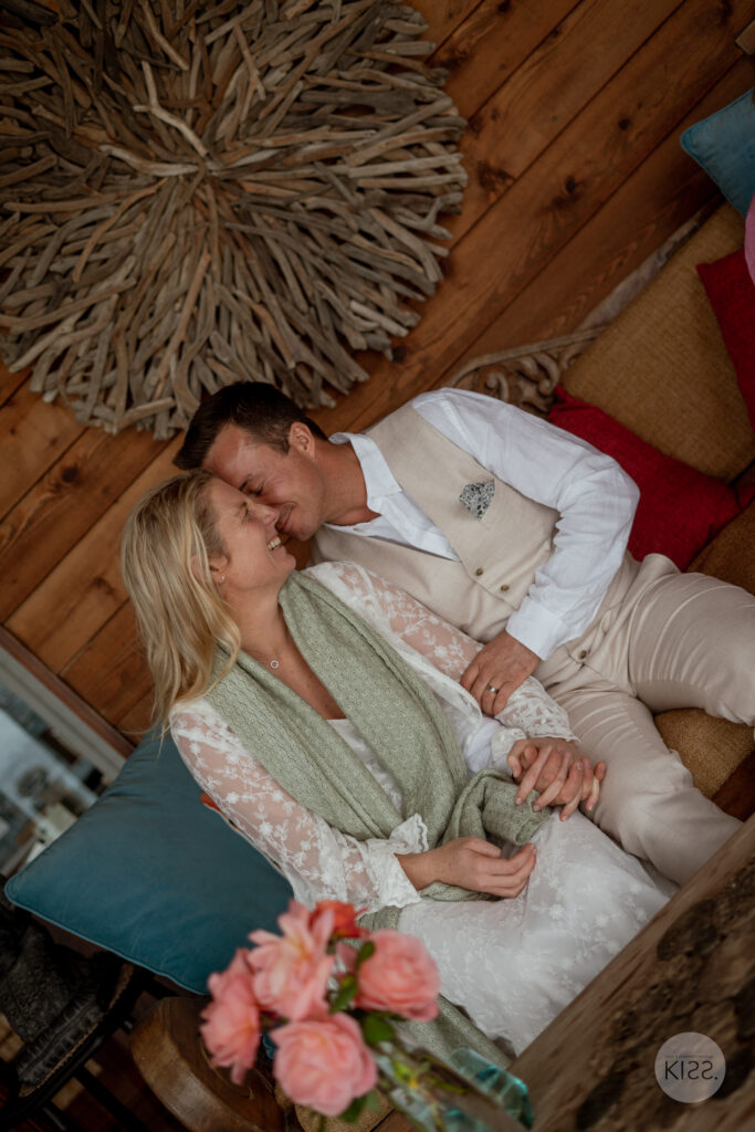 A wedding couple relaxing together on a sofa
