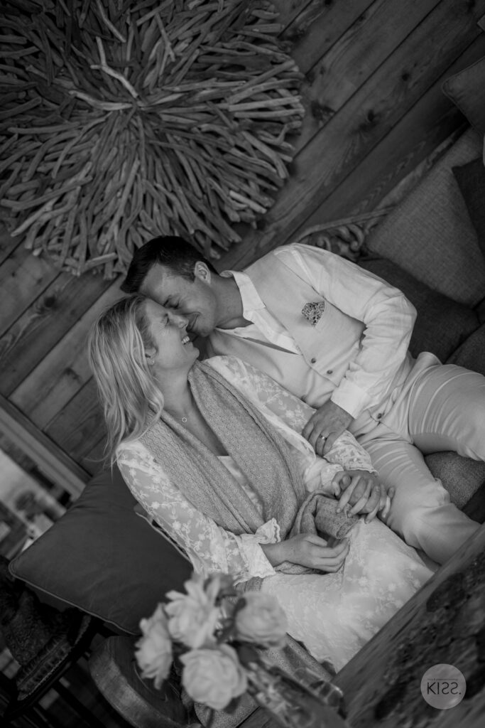 A wedding couple relaxing together on a sofa in black and white