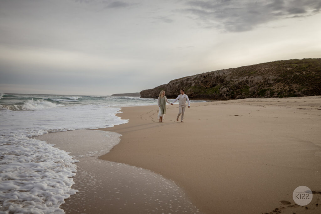 A wedding couple walking along the shoreline