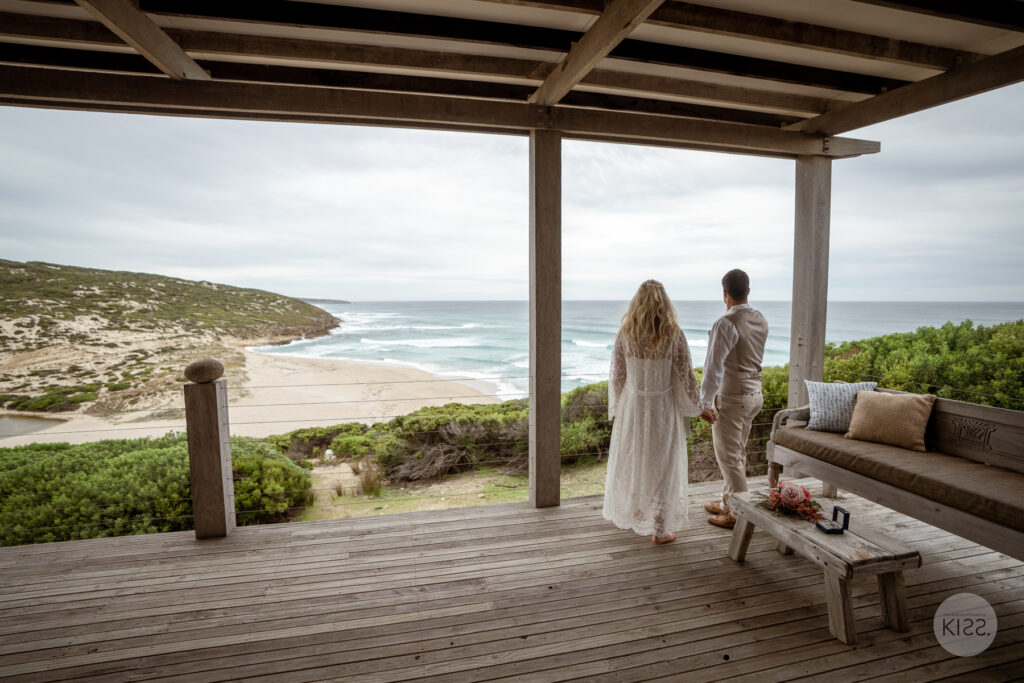 A couple looking out to sea from a coastal deck
