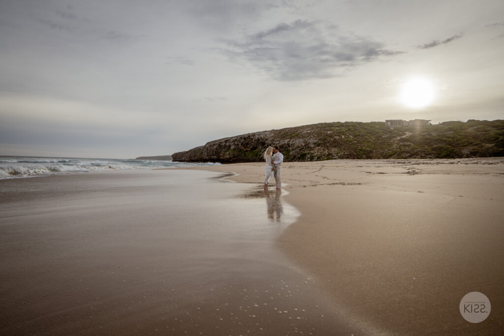 A couple standing on a wide empty beach on Kangaroo Island