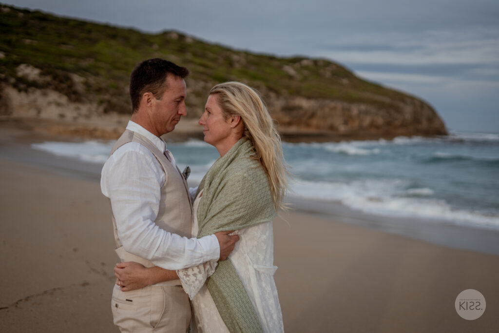 A couple smiling together at the water's edge