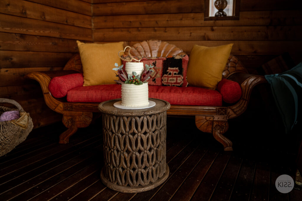 Wedding cake on a round table beside colourful seating