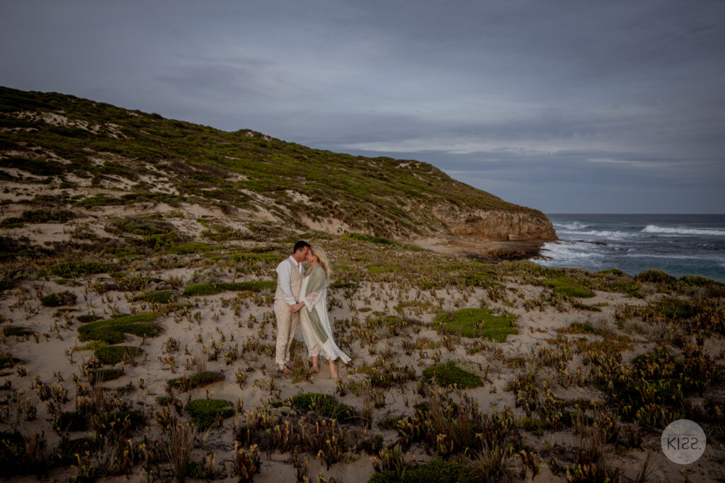 A wedding couple embracing among coastal vegetation