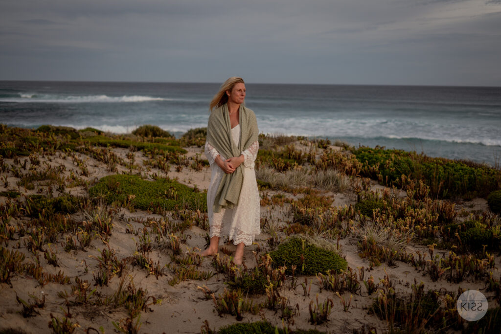 A bride standing among low coastal plants