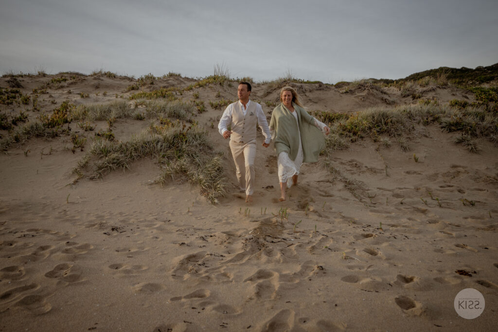 A couple playing together on coastal sand dunes