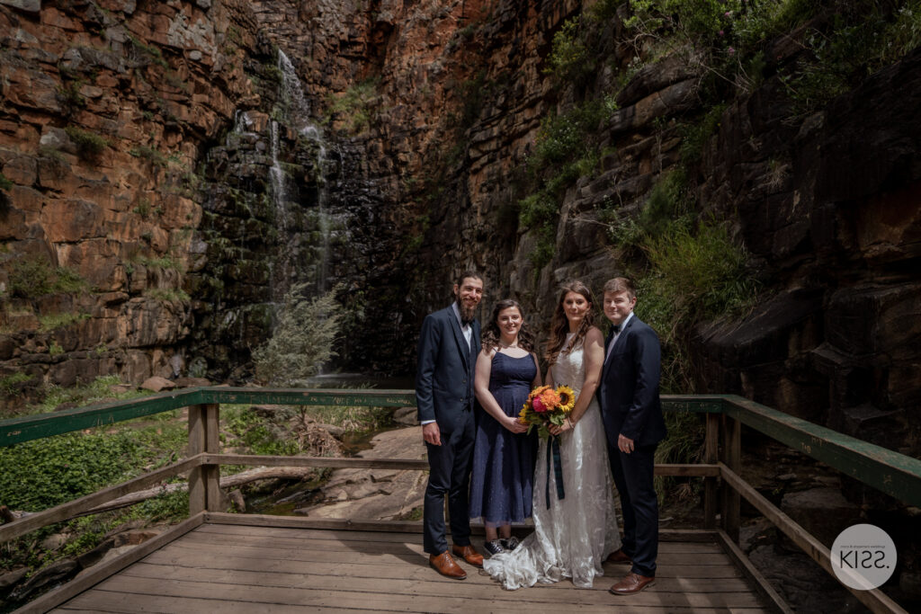 A wedding party posing on a bridge at Morialta