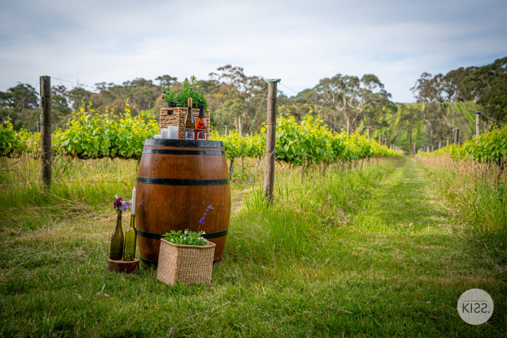 Wine barrel and flowers beside a vineyard