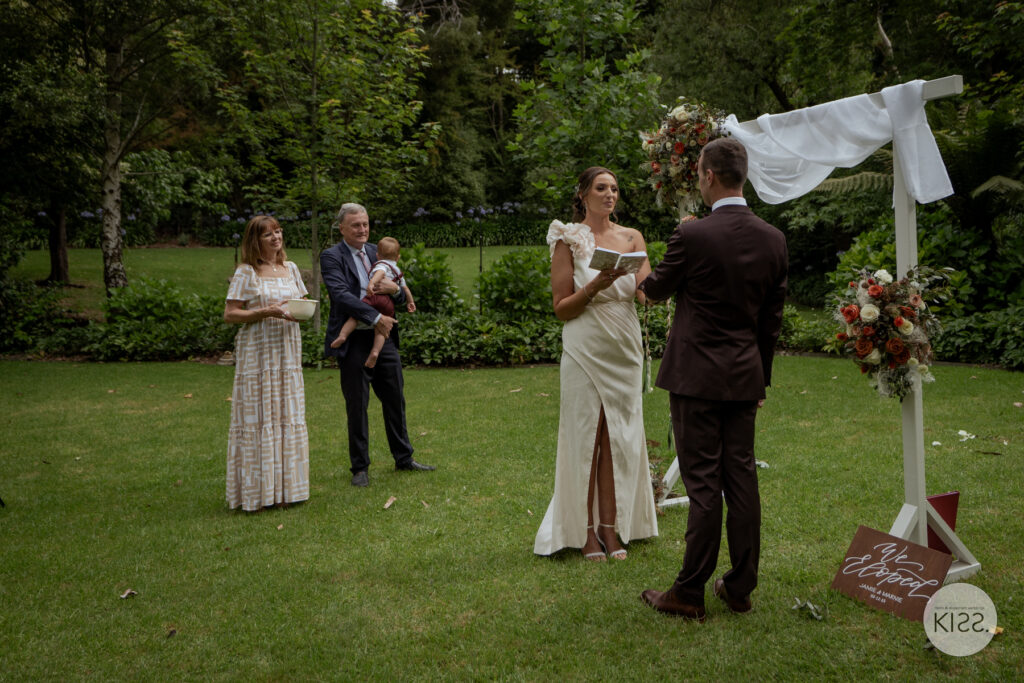 A bride reading her vows in a garden ceremony
