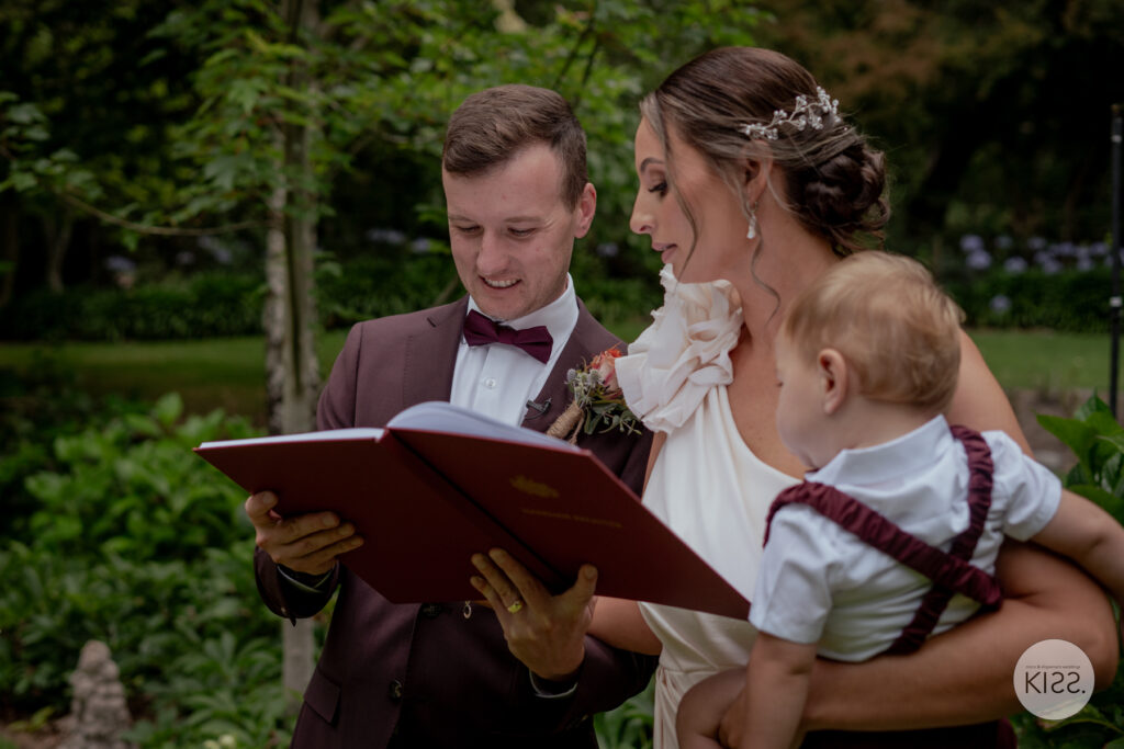 A wedding couple and their baby looking at a marriage document