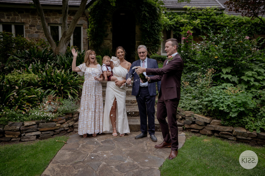 A small wedding group celebrating with drinks in a garden