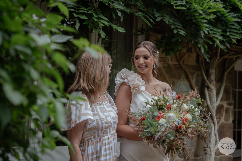 A bride holding her bouquet and talking to a guest