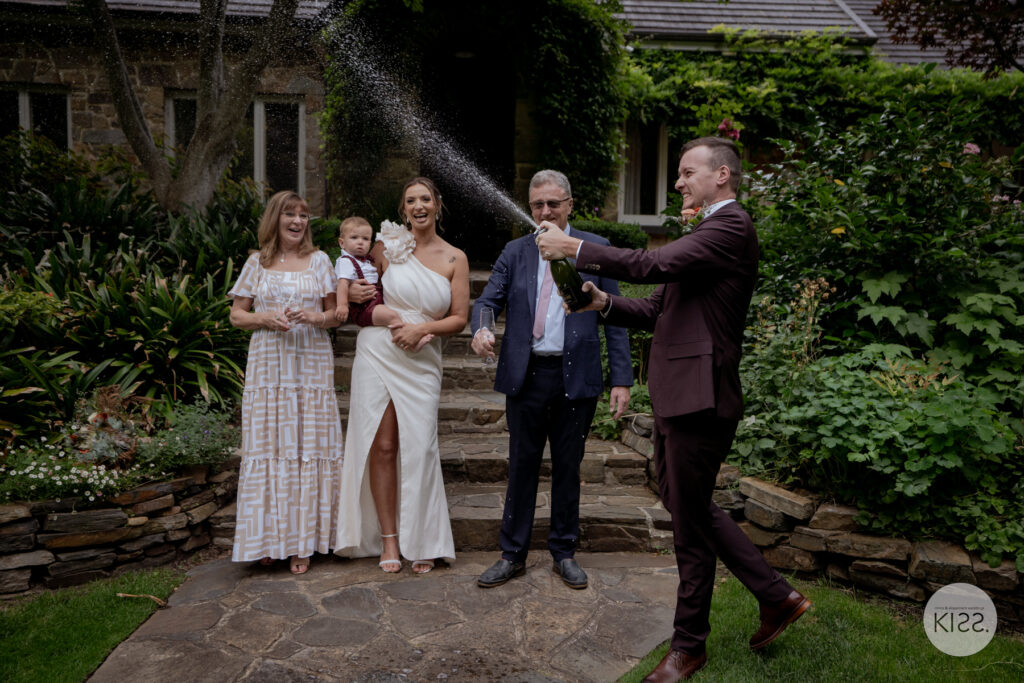 A small wedding group making a toast in a garden