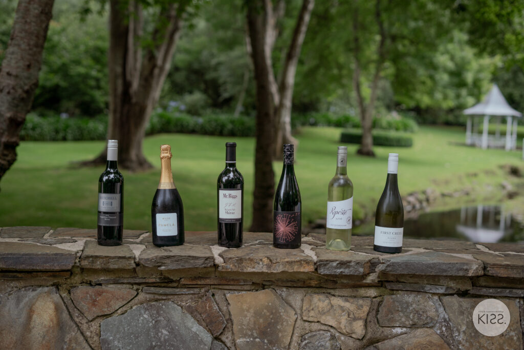 Wine bottles arranged on a stone garden wall