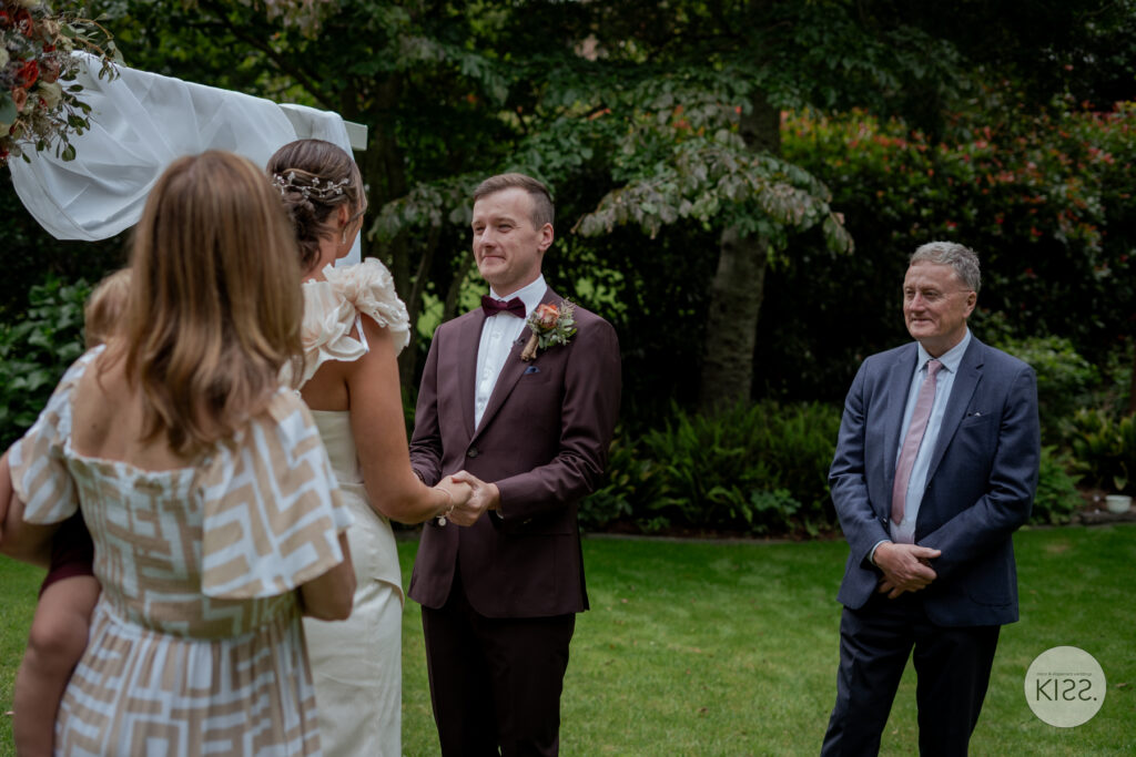 A groom speaking to his bride and celebrant during the ceremony