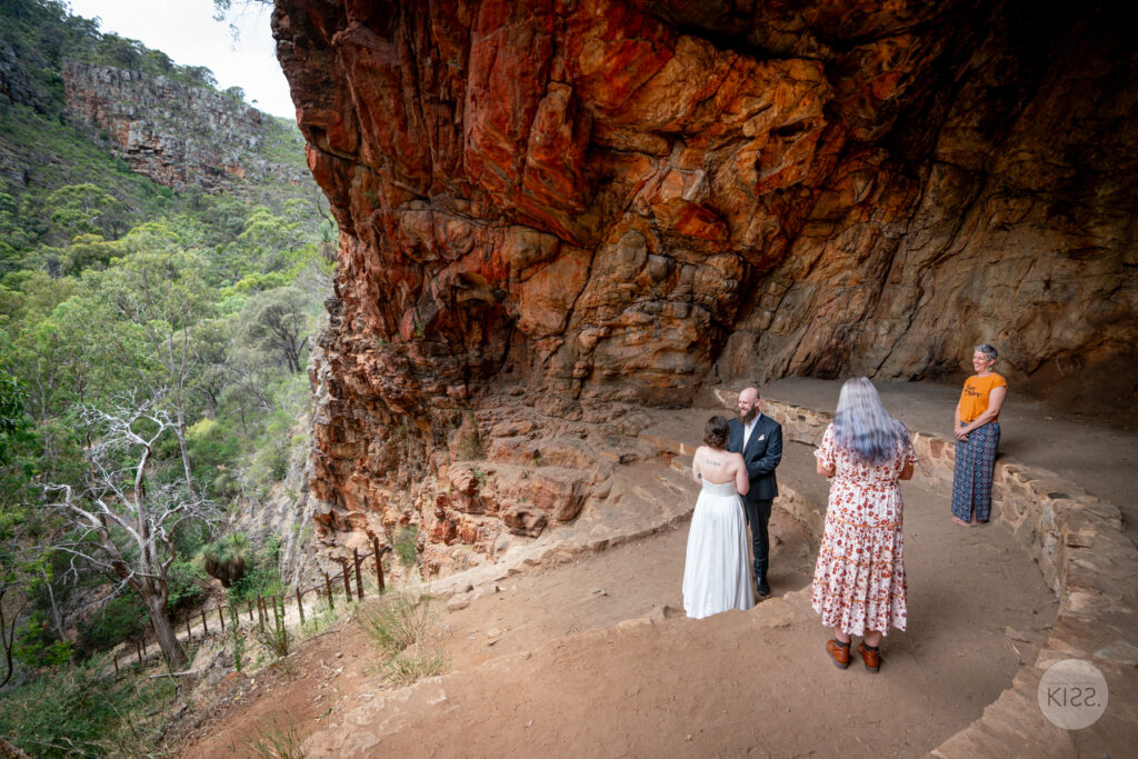 A small wedding party gathered inside a rocky cave