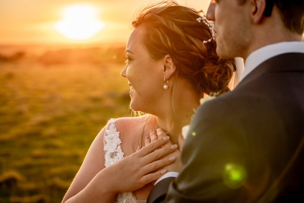A wedding couple together in golden sunset light