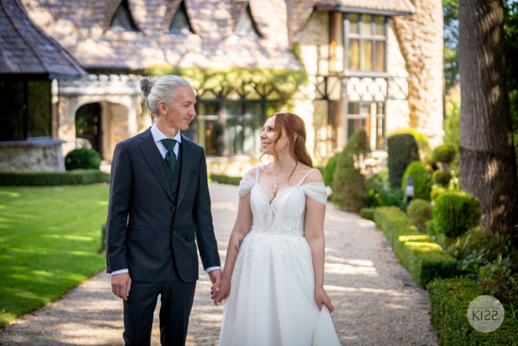 A wedding couple walking through Thorngrove Manor gardens