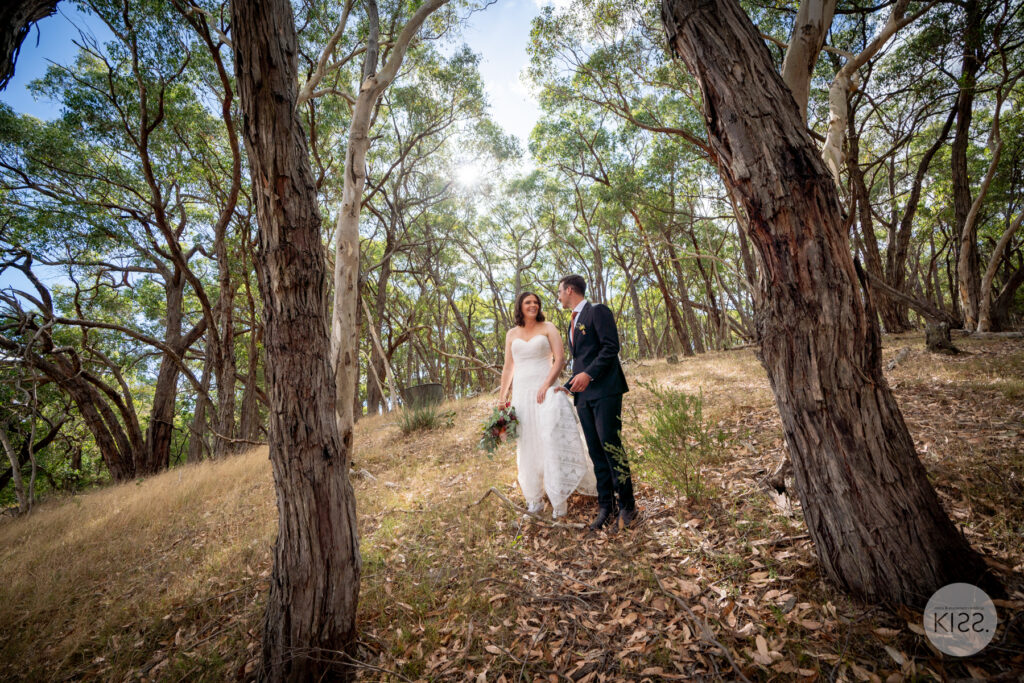 A wedding couple embracing among gum trees