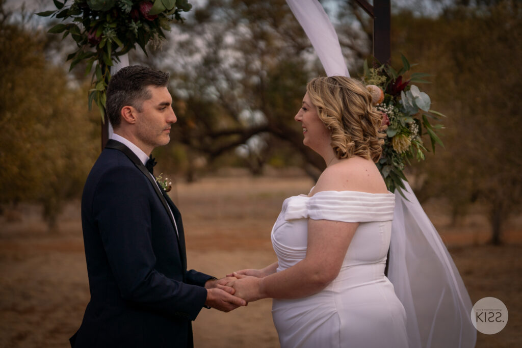 A couple holding hands during their wedding ceremony