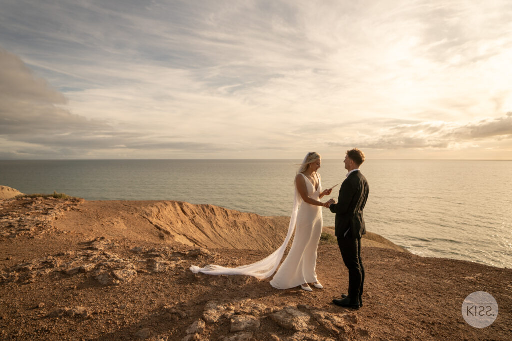 A newly married couple at sunset above the coast at Port Willunga