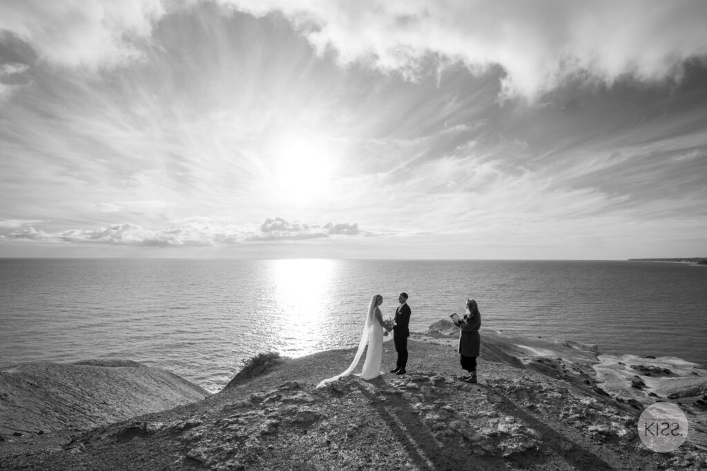 A small cliffside wedding ceremony in black and white