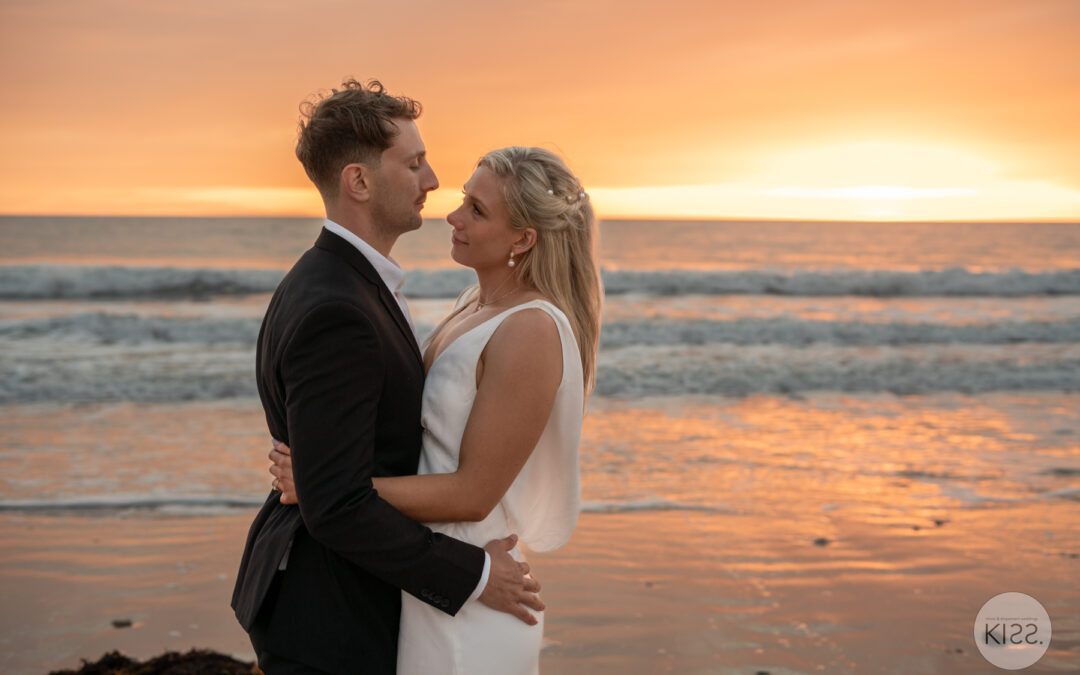 Couple eloping at Glenelg Beach with a simple wedding arch by KISS Package.