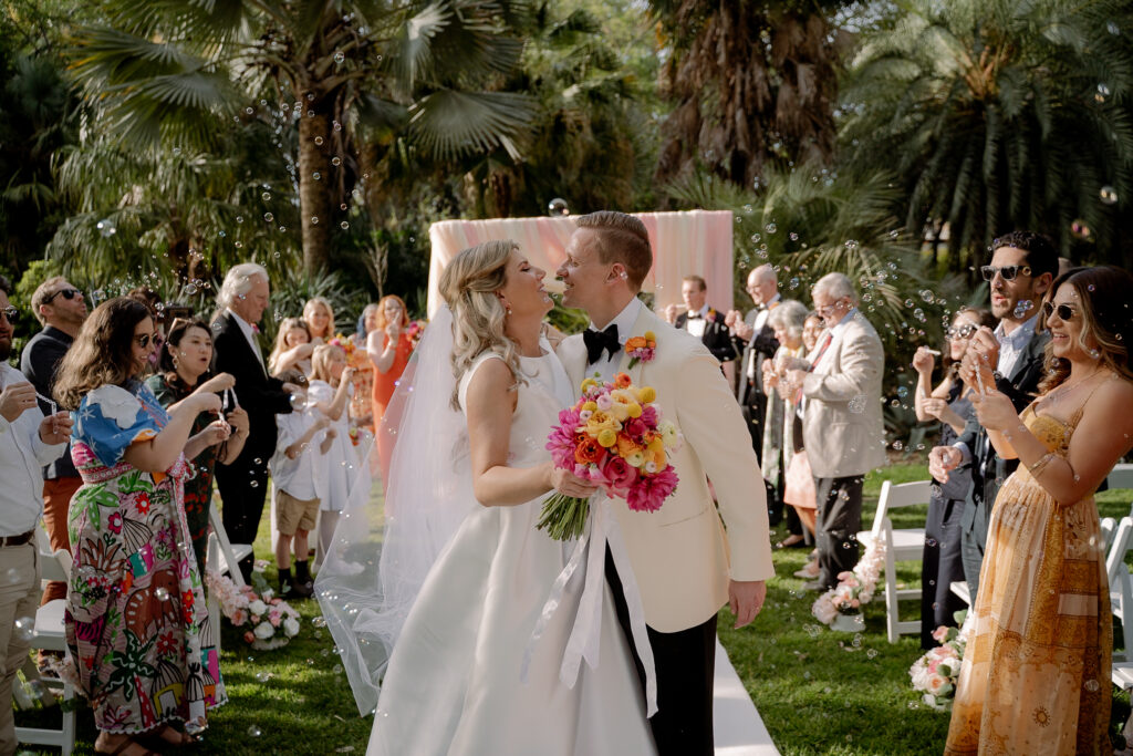 A newly married couple walking past applauding wedding guests