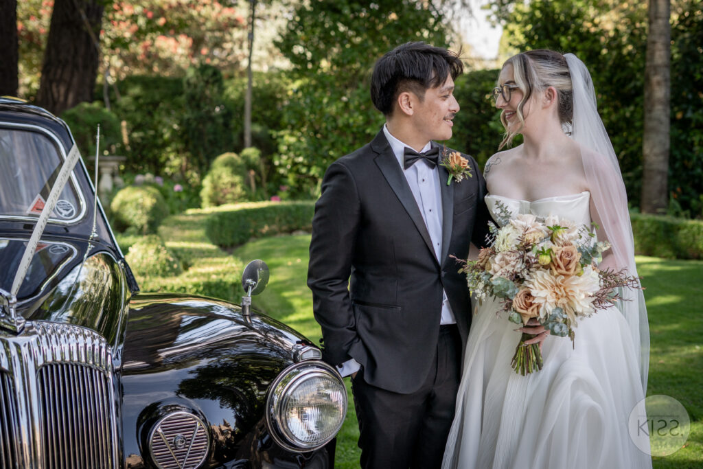 A bride and groom beside a vintage Daimler at Thorngrove Manor
