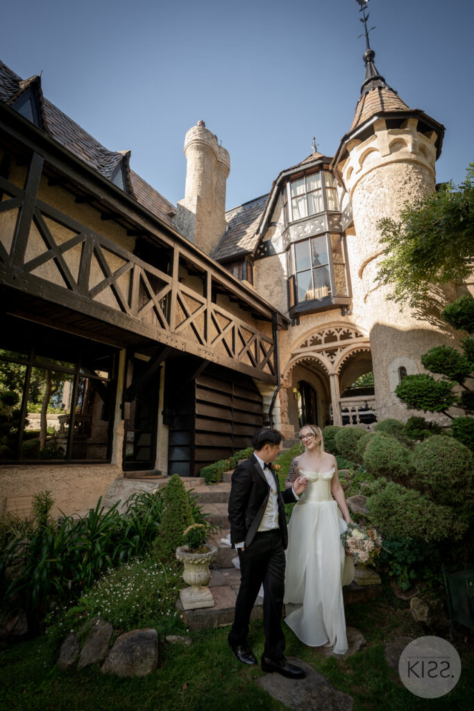 Couple standing in front of the castle style architecture at Thorngrove Manor in the Adelaide Hills.