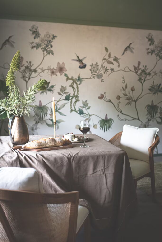 Indoor table setting beside botanical wallpaper