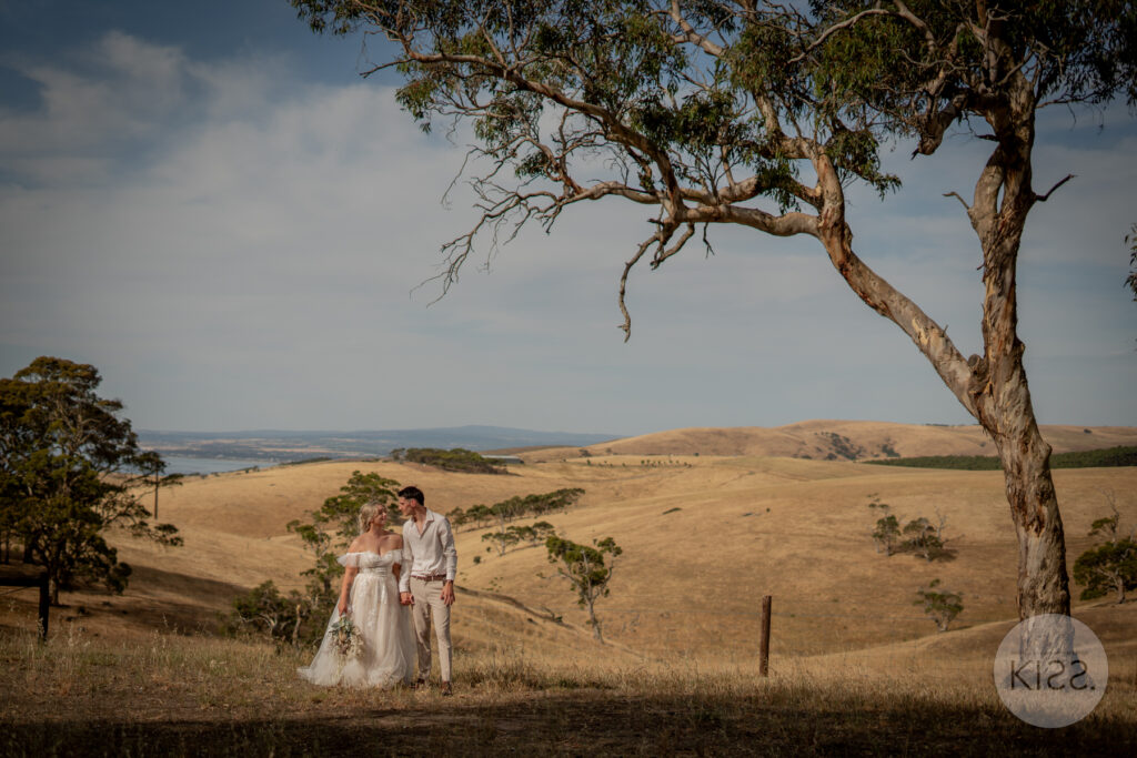 A wedding couple embracing beneath a tree at Fleurieu Gin