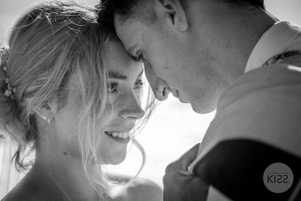 A wedding couple touching foreheads in black and white